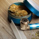 marijuana-joint-and-pipe-on-warm-lighted-table-picture-id8959136581